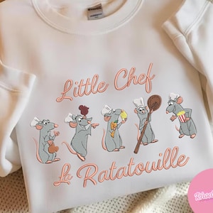 Pode incluir: Camisola branca com bordado coral "Little Chef La Ratatouille". Apresenta cinco ratos chefes de desenho animado com chap&eacute;us brancos, cada um segurando um utens&iacute;lio de cozinha. Um design divertido e acolhedor.