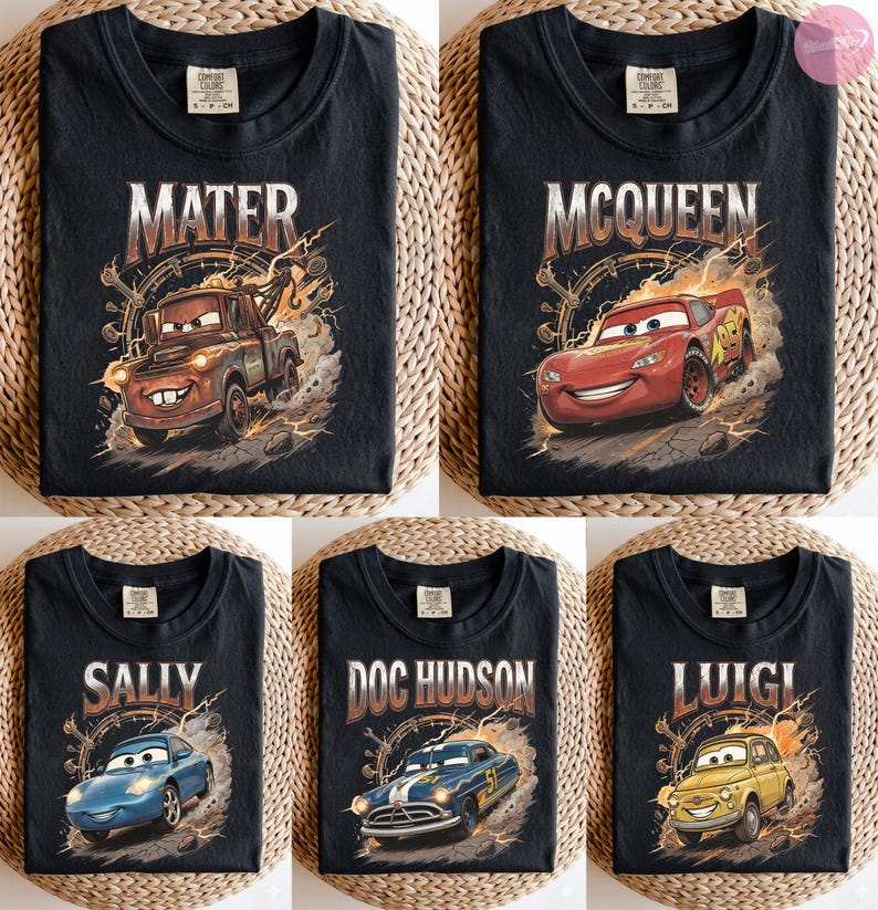 May include: Black t-shirts featuring characters from the movie "Cars". Each shirt displays a different character's name: Mater, McQueen, Sally, Doc Hudson, and Luigi, along with an illustration of the character. The designs have a vintage, distressed look.
