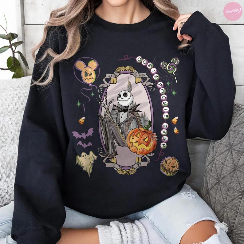 May include: A black long-sleeve sweatshirt featuring a graphic print of Jack Skellington holding a pumpkin. The design includes the text "Oogie Boogie Bash," "Jack Skellington," and "1993," surrounded by illustrations of ghosts, bats, and candy corn.