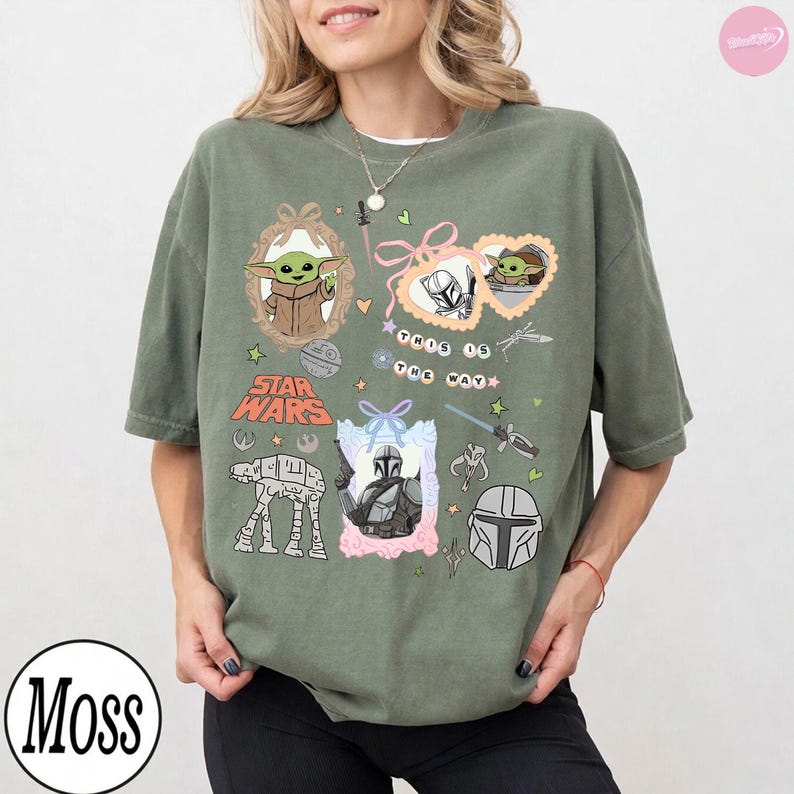 May include: Olive green t-shirt featuring Star Wars graphics, including Grogu, the Mandalorian, and AT-AT walker illustrations. The shirt also has the text "This is the Way" and the "Star Wars" logo.