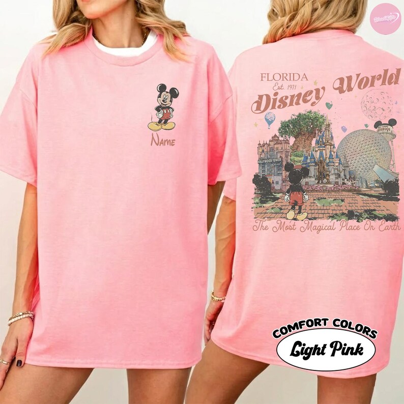 Puede incluir: Camiseta rosa claro con Mickey Mouse en la parte delantera y un dise&ntilde;o de Disney World en la parte trasera. La parte delantera tiene la imagen de Mickey y la palabra "Name". La parte trasera tiene las palabras "Florida Disney World" y "The Most Magical Place On Earth".