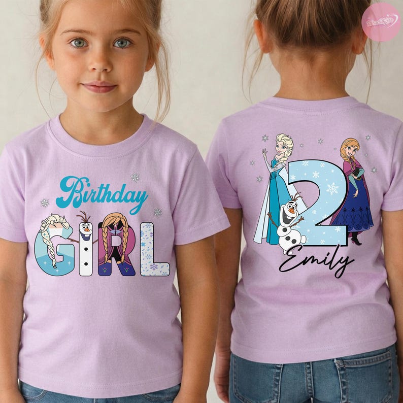 May include: A light purple t-shirt with the words "Birthday Girl" in blue script and featuring cartoon characters. The back of the shirt has a large number "2" with the name "Emily" and more cartoon characters.