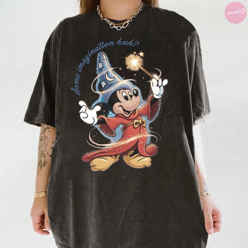 K&ouml;nnte beinhalten: Dunkelgraues T-Shirt mit einem Cartoon-Mickey-Mouse-Zauberer-Design, der einen Zauberstab mit Funkel-Effekt h&auml;lt. Der Text "some imagination huh?" steht &uuml;ber der Figur. Das T-Shirt hat einen Vintage-Look.