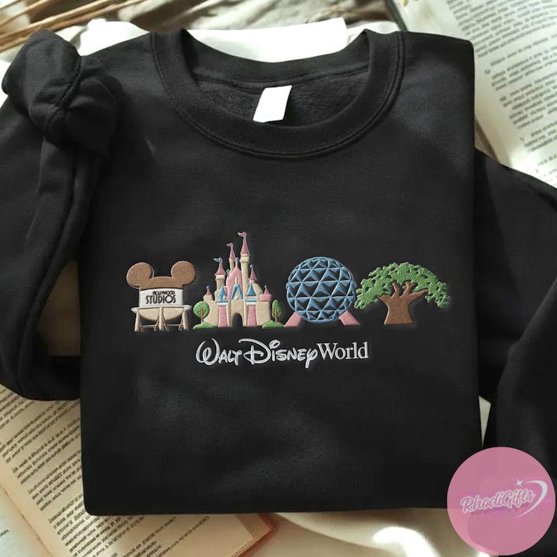 Peut inclure: Sweat-shirt noir &agrave; col rond avec un motif brod&eacute; de Walt Disney World. Le motif comprend les c&eacute;l&egrave;bres oreilles de Mickey Mouse, un ch&acirc;teau, une sph&egrave;re g&eacute;od&eacute;sique et un arbre. Les mots "Walt Disney World" sont brod&eacute;s en dessous.