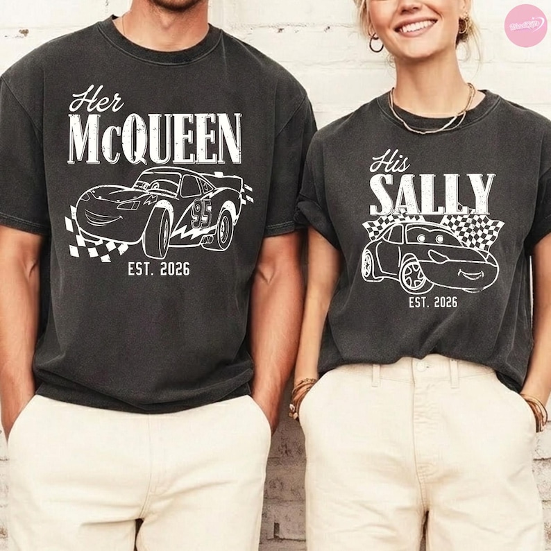 May include: Two charcoal gray t-shirts with white graphics. One says "Her McQueen" with a race car design and "EST. 2026". The other says "His Sally" with a similar car design and "EST. 2026".