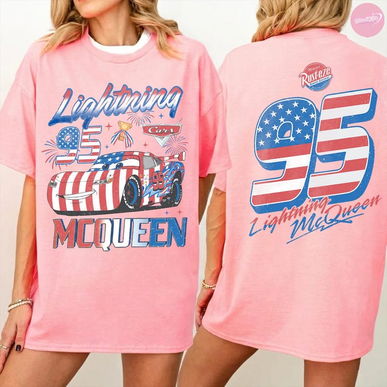 May include: Pink t-shirt featuring a graphic of Lightning McQueen from the Cars movie. The front design includes the number 95, the name "Lightning McQueen," and a patriotic car design. The back of the shirt also displays the number 95 and the name "Lightning McQueen."