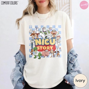 Puede incluir: Una camiseta de color marfil con un estampado gr&aacute;fico de varios personajes de dibujos animados vestidos como personal m&eacute;dico. El texto NICU STORY est&aacute; centrado en amarillo y rojo. El fondo del gr&aacute;fico es un patr&oacute;n de cuadros azul claro y blanco.