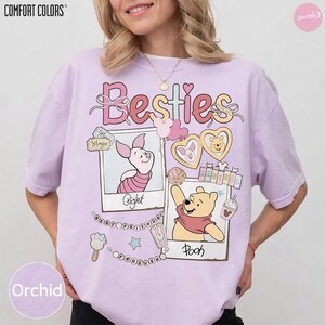 Puede incluir: Camiseta color orqu&iacute;dea con la palabra "Besties" en escritura rosa. La camiseta muestra ilustraciones de Piglet y Winnie the Pooh, con las palabras "Piglet" y "Pooh" debajo de sus im&aacute;genes. La camiseta tambi&eacute;n tiene las palabras "Best Friends Forever".