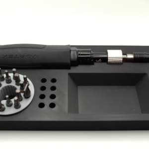 May include: A black Vortex brand screwdriver set with various bits and a socket wrench. The set includes a black handle, a silver and black adjustable shaft, and a tray with multiple compartments for organization.