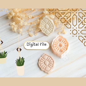 May include: Three cookie cutters with a floral design in beige and peach tones are arranged on a light wood surface. The text "Digital file" is displayed. Decorative plants in hanging pots and a floral pattern are also visible.