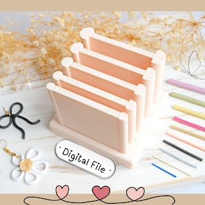 Könnte beinhalten: Ein hellpfirsichfarbener Ohrring-Präsentationsständer mit mehreren Schlitzen, beschriftet mit Maßen. Das Bild zeigt auch farbige Stäbe, eine schwarze Schleife, einen Gänseblümchen-Ohrring und den Text "Digital File".