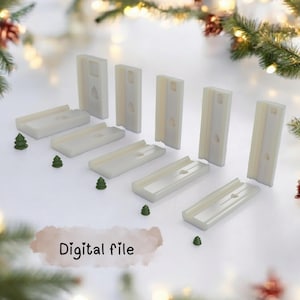 May include: A collection of off-white rectangular and vertical objects, possibly molds or forms, arranged on a white surface. Small green Christmas tree decorations are scattered around the objects. The words "Digital file" are displayed in the image.