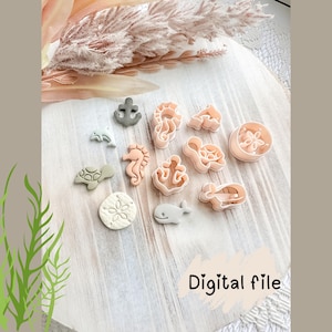 May include: A selection of sea-themed cookie cutters, featuring a seahorse, turtle, and anchor, in shades of pink, grey, and white. They are arranged on a light wood surface. The words "Digital file" are also visible.