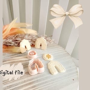 Puede incluir: Una colección de cortadores de galletas y galletas con forma de arcoíris y flores, con una ilustración de lazo en el fondo. El texto "Digital file" es visible en la esquina inferior izquierda. Los artículos están dispuestos sobre una superficie de madera blanca.