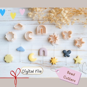 Puede incluir: Una colección de cortadores de cuentas de varias formas, como nubes, lunas, estrellas y mariposas. Los cortadores son de colores neutros y se muestran sobre una superficie de madera clara. La imagen incluye el texto "Digital file" y "Bead Cutters".