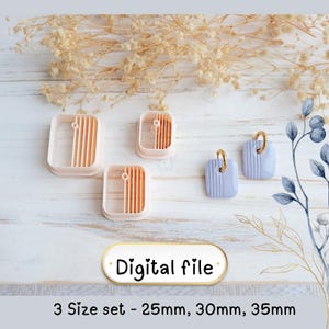 Op de afbeelding: Een set van drie vierkante kleisnijders in verschillende maten, samen met twee afgewerkte oorbellen. De snijders zijn perzik van kleur met verticale groeven. De oorbellen zijn lichtblauw met gouden ringen. De tekst "Digital file" en "3 Size set - 25mm, 30mm, 35mm" zijn zichtbaar.