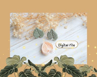 May include: Three leaf-shaped objects, two in a muted green and one in a light peach color, are displayed on a white wooden surface. The leaves have detailed vein patterns. The text "Digital file" is in a white oval. The background includes dried flowers.