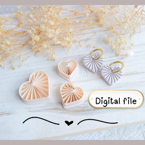 Op de afbeelding: Een verzameling hartvormige objecten in roze en wit, waaronder twee sleutelhangers met gouden ringen en twee hartvormige mallen. De tekst "Digital file" staat op een witte ovaal.