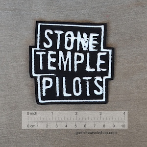 Puede incluir: Parche bordado en blanco y negro con el texto "STONE TEMPLE PILOTS" en forma rectangular.