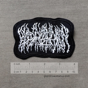 Op de afbeelding: Zwarte geborduurde patch met witte letters die "WARHORSE" lezen in een gestileerd lettertype. De patch is ongeveer 7,6 cm breed en 5,1 cm hoog.