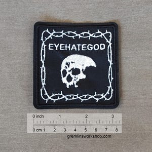 May include: Black embroidered patch with white barbed wire border, a skull, and the text "EYEHATEGOD".