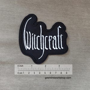 May include: Black embroidered patch with the word "Witchcraft" in white lettering. The patch is approximately 3 inches wide.