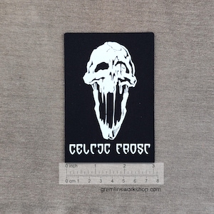 Puede incluir: Parche rectangular negro con un diseño de calavera blanca con rasgos goteantes. El texto "CELTIC FROST" está impreso en blanco debajo. El parche mide aproximadamente 7.6 cm de largo.