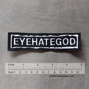 Puede incluir: Parche bordado negro con texto blanco que dice "EYEHATEGOD".