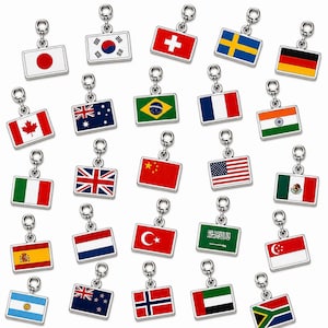 Può includere: Una collezione di ciondoli rettangolari in metallo, ognuno con una bandiera smaltata colorata di varie nazioni, tra cui Giappone, Corea del Sud, Svizzera, Svezia, Germania, Canada, Australia, Brasile, Francia, India, Italia, Regno Unito, Cina, USA, Messico, Spagna, Paesi Bassi, Turchia, Arabia Saudita, Singapore, Argentina, Nuova Zelanda, Norvegia, Emirati Arabi Uniti e Sudafrica.