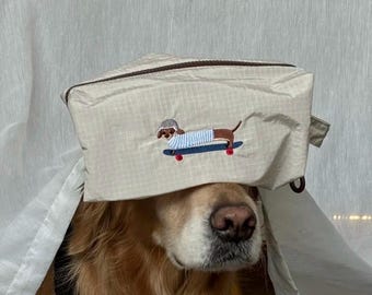 Beige sminkväska med taxmotiv: Broderad reseväska för hundälskare