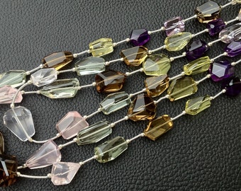 May include: Multi-strand gemstone necklaces featuring faceted, irregular-shaped beads in various colors including brown, yellow, purple, pink, and clear. The beads are strung on silver-colored wire, creating a layered effect. The background is a textured black surface.