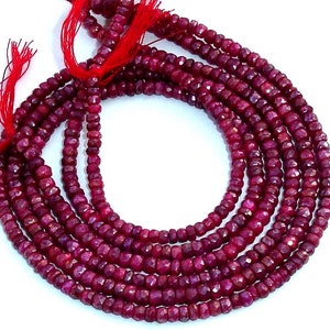 Puede incluir: Cadenas de cuentas de rubí rojo oscuro facetadas. Las cuentas están ensartadas con un hilo rojo, creando un efecto en capas. Las piedras preciosas tienen una superficie pulida y reflectante, adecuadas para la creación de joyas.