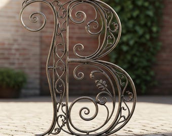Può includere: Lettera "B" in metallo ornato con finitura bronzo. La sceneggiatura decorativa presenta disegni a vortice e accenti di foglie. La lettera si erge su un patio in mattoni con uno sfondo sfocato di mattoni e vegetazione.