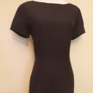 May include: A black, short-sleeved dress with a scoop neckline. The dress is form-fitting and appears to be made of a smooth fabric. The dress is displayed on a mannequin.