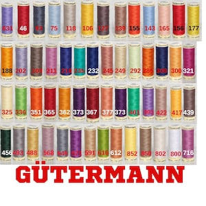 Puede incluir: Una colección de carretes de hilo Gütermann en varios colores, incluyendo rojo, azul, verde y amarillo. Cada carrete está etiquetado con un número y la marca Gütermann. La imagen es un primer plano de los carretes de hilo.