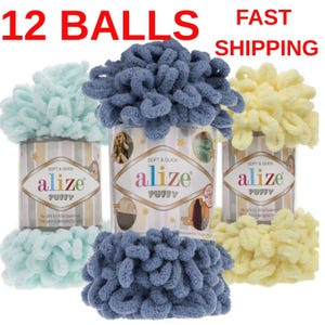 Op de afbeelding: Een assortiment Alize Puffy garen in verschillende kleuren, waaronder blauw, geel en mintgroen. Elke bol garen wordt in een cilindrische container gepresenteerd. De tekst "12 BALLS" en "FAST SHIPPING" is zichtbaar.