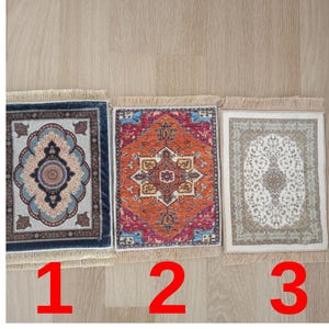 Könnte beinhalten: Drei kleine Teppiche mit Fransen an den Rändern. Der Teppich links hat ein blaues und weißes Muster, der mittlere Teppich hat ein rotes, oranges und blaues Muster und der Teppich rechts hat ein beigefarbenes und weißes Muster.