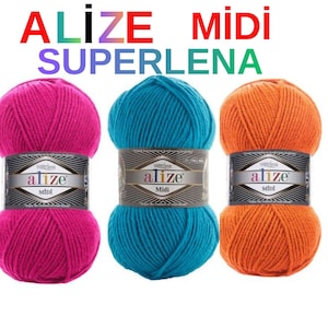 Op de afbeelding: Drie bollen Alize Midi Superlana garen in levendige kleuren: felroze, turquoise en oranje. Elke bol heeft een etiket met de merknaam en productdetails. Ideaal voor brei- en haakprojecten.