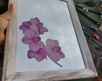 Op de afbeelding: Een rechthoekige spiegel met een verweerde witte houten lijst. Het spiegeloppervlak toont een aquarel-illustratie van roze orchideeën. De lijst heeft een rustieke, verweerde uitstraling, wat een vleugje vintage charme toevoegt.