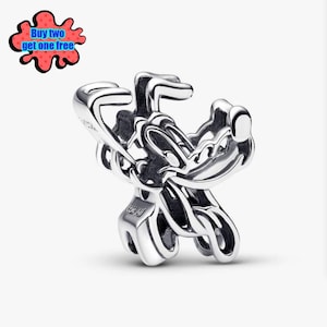 May include: A silver charm depicting a cartoon character. The charm features intricate detailing with curved lines and a polished surface. The text "Buy two get one free" is in a speech bubble in the upper left corner.