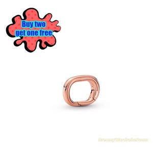 May include: Rose gold-colored oval-shaped jewelry clasp. The clasp is a link with a hinged opening. The image also includes a red and black graphic with the text "Buy two get one free".