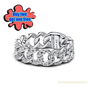 May include: A silver ring with a chain link design, encrusted with clear gemstones. The ring is marked "PANDORA S925 ALE". A red and black graphic with the text "Buy two get one free" is in the upper left corner.