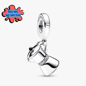 Puede incluir: Un charm de plata con un diseño de cafetera. El charm tiene un lazo en la parte superior con la palabra "Pandora" grabada. La cafetera tiene una banda de piedras transparentes. La imagen también incluye el texto "Buy two get one free".