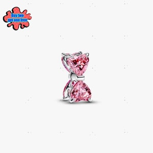 May include: A silver charm featuring two pink heart-shaped gemstones, one above the other, joined by a silver band. The gemstones are multi-faceted, reflecting light. This charm is a piece of jewellery.