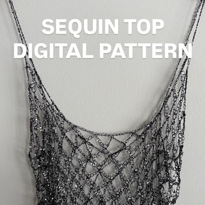 May include: A black sequin top digital pattern hangs from a wooden hanger against a white wall. The top is made of a chain-like mesh with sequins, creating a shimmering effect. The text "SEQUIN TOP DIGITAL PATTERN" is displayed in white.