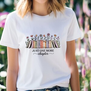 May include: White t-shirt with a graphic of books and flowers, and the text "JUST ONE MORE chapter". The design features a row of books with colorful spines, and various flowers. The text is in a decorative font.