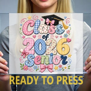 May include: A clear glass panel with a colorful graduation design. The design includes the words "Class of 2026 Senior" in a patchwork style, along with a graduation cap, bows, and floral accents. The text "READY TO PRESS" is at the bottom.