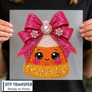 May include: A DTF transfer featuring a candy corn character with a large, glittery hot pink bow. The bow is adorned with a central pearl-like accent and small floral embellishments. The candy corn has a smiling face, rosy cheeks, and a textured, sparkling finish in shades of orange and yellow.