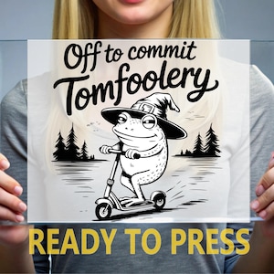 May include: A black and white graphic featuring a frog riding a scooter, wearing a witch hat, and the text "Off to commit Tomfoolery." Below, the text reads "READY TO PRESS."