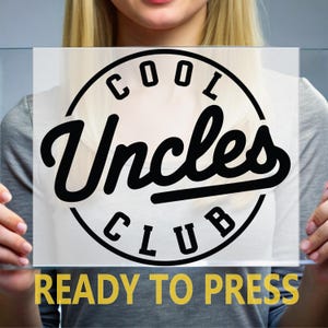 May include: A clear rectangular sign with the words "COOL Uncles CLUB" in a black circular design. Below the design, the words "READY TO PRESS" are in yellow.